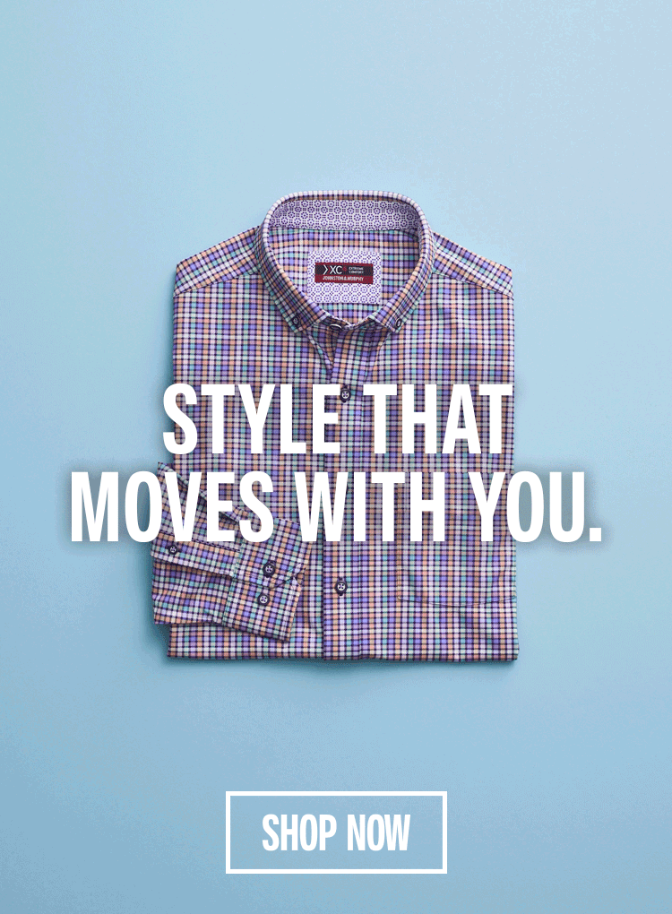 A woman sitting on stone steps dressed in a blue blazer, white pants, and a light tan colored woven loafer.